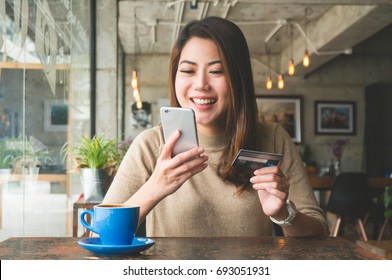 Asian Woman Shopping Online With Credit Card Payment In Coffee Shop Feeling Happy Smile