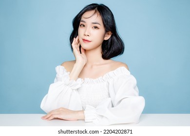 Asian woman short hair with Perfect clean fresh skin. Cute female model with natural makeup and sparkling eyes on blue isolated background. Facial treatment, Cosmetology, beauty Concept. - Powered by Shutterstock