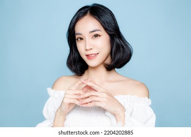 Asian woman short hair with Perfect clean fresh skin. Cute female model with natural makeup and sparkling eyes on blue isolated background. Facial treatment, Cosmetology, beauty Concept. - Powered by Shutterstock