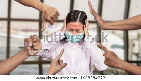Asian woman was sick with high fever wearing hygienic mask are bullied and hate surrounded by hands mocking her, scoffing in the outbreak situation of Coronavirus 2019 infection or Covid-19
