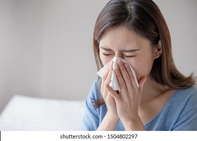 asian woman sick and sneeze with tissue paper in the bedroom - Powered by Shutterstock
