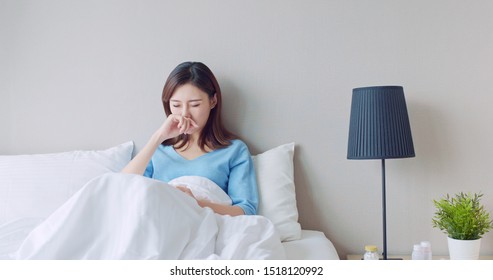 Asian Woman Sick And Sneeze With Tissue Paper In The Bedroom