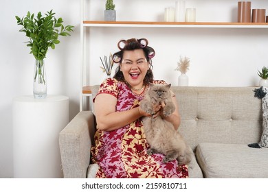 An Asian Woman Sitting At Her Living Room And Play With Her Pet. Expressive.