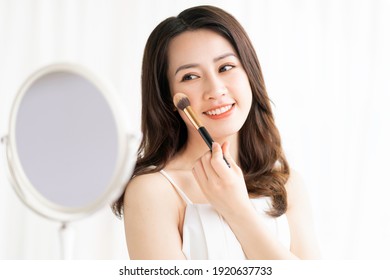 Asian Woman Sitting Makeup In Front Of Mirror