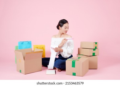 Asian Woman Sitting On The Floor And Checking Expenses On The Bill After Moving Into New House