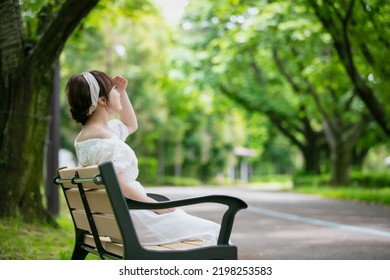 Asian Woman Sitting On A Park Bench (hot, Intense Heat)