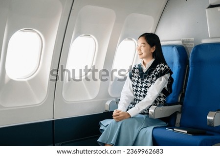 Asian woman sitting in a seat in airplane and looking out the window going on a trip vacation travel concept.Capture the allure of wanderlust with this stunning image in morning

