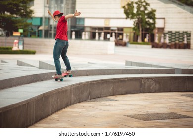 Asian woman skateboarder wearing facemask skateboarding in modern city - Powered by Shutterstock