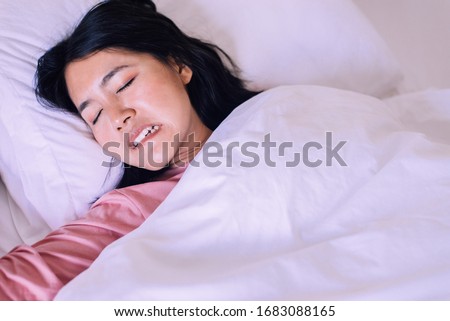 Asian woman sleeping and grinding teeth in bedroom,Female tiredness and stress