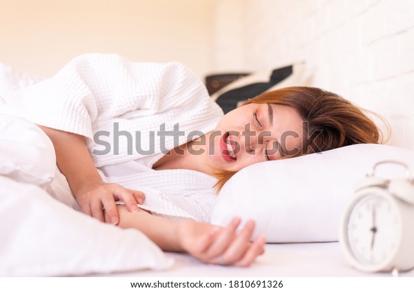 Asian woman sleeping on the bed and\
grinding teeth,Female bruxism,Gnash or clench your\
teeth