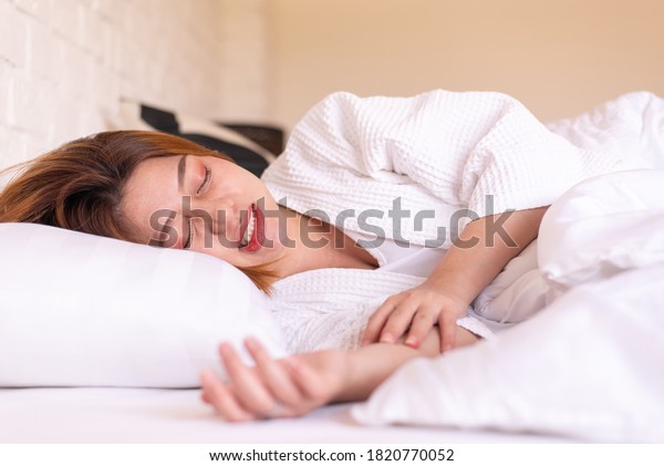 Asian woman sleeping on the bed and grinding\
teeth,Female tiredness and\
stress