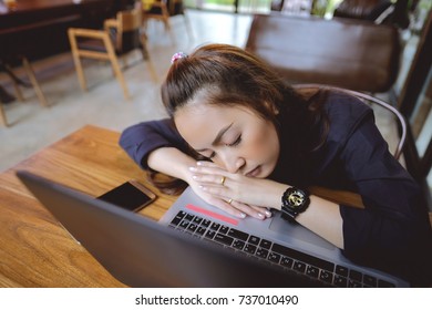 Asian woman sleeping on her laptop