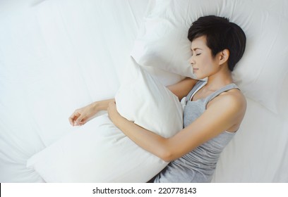 Asian Woman Sleeping In White Bed, View From Above