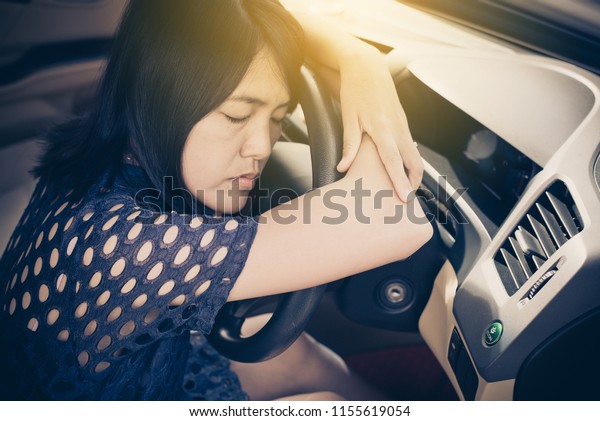 Asian woman sleepy tired and have a headache while\
driving car