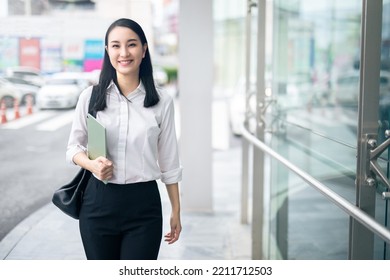 Asian woman with smartphone walking against street blurred building background, Fashion business photo of beautiful girl in casual suite with smart phone.  - Shutterstock ID 2211712503