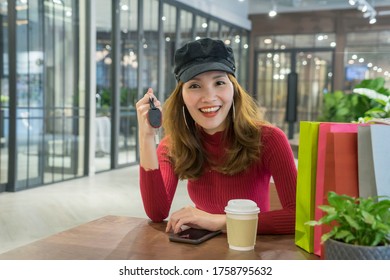 ํYoung Asian Woman Is Smiling, Picking Up The Keys, Renting A Car While Waiting For Online Shopping, Drinking Coffee, Waiting At The Coffee Shop.