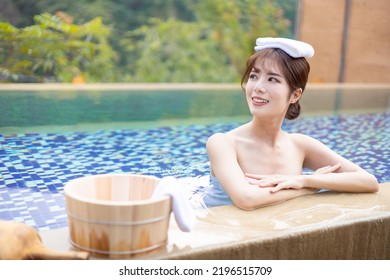 Asian woman smilling sitting in the hotspring