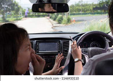 Asian Woman Smoking Cigarette While Driving Inside The Car And The Child Choking Of Smoke,stop Smoking 