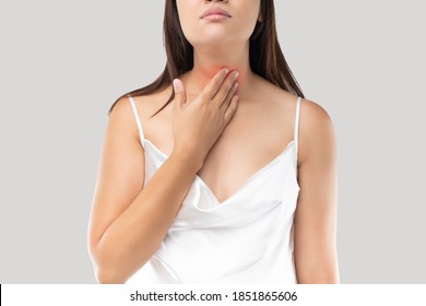 Asian Woman With A Sore Throat Or Thyroid Gland Against The Gray Background. Acid Reflux Or Heartburn, Neck Pain, People Body Problem Concept