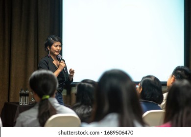 asian woman speaking over white screen in seminar - Powered by Shutterstock