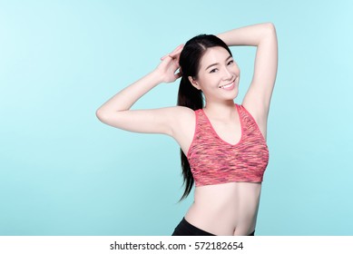 Asian Woman Sport Workout And Exercise Concept. Slim Body Girl Warm Up Before Workout. Beauty Face And Natural Makeup Sports Bra Outfit. Isolated Over Blue Background