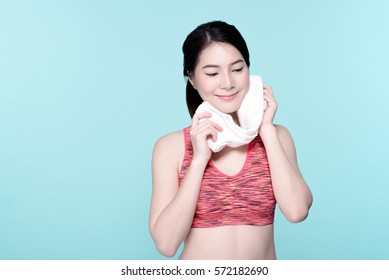 Asian Woman Sport Workout And Exercise Concept. Slim Body Girl Relax And Wipe Sweat After Workout. Beauty Face And Natural Makeup Sports Bra Outfit. Isolated Over Blue Background