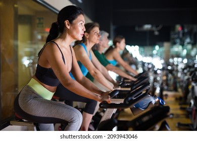 Asian Woman In Sportive Activewear Training On Bike In Spin Class At Gym