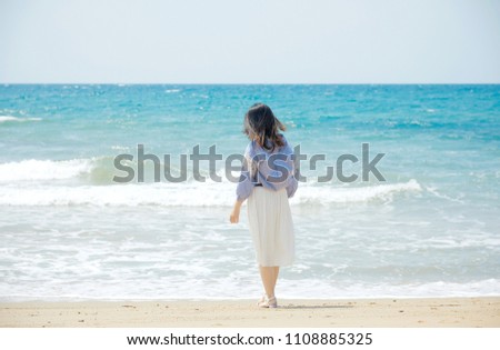 Asian woman standing at the beach