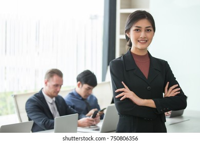 Asian Woman Standing In Front Of Her Team With Smiling, Female With Her Team Working In The Office, Woman Leader Concept.