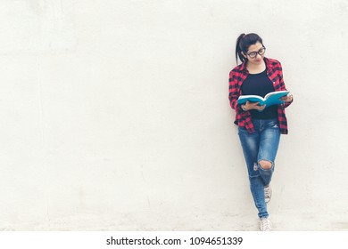 Asian Woman Standing And Holding A Book On Wall White Background.  Education Concept
