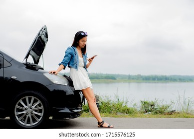 Asian woman standing  on roadside with car breadown using mobile phone , female using  smartphone with damaged car after a car accident , Insurance assistance Concept - Powered by Shutterstock