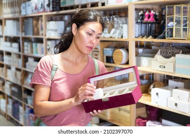 Asian Woman Standing In Store And Holding Cosmetic Storage Box In Hands.