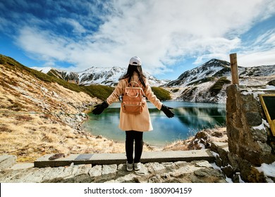 Asian woman is standing at swamp that is named Mikurigaike in Tateyama-Kurobe alpine route or Japan Alps in Toyama, Japan