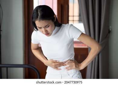 Asian Woman With Stomach Ache, Concept Of Menstrual Period Cramp, Abdominal Pain, Food Poisoning, Gastritis, Acid Reflux Or Colon Cancer