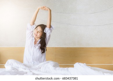 Asian Woman Stretching In Bed After Wake Up In Morning With Sunlight