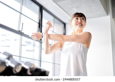 Asian woman stretching in a training gym - Powered by Shutterstock