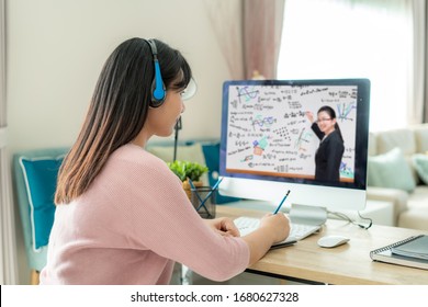 Asian Woman Student Video Conference E-learning With Teacher On Computer In Living Room At Home. E-learning ,online ,education And Internet Social Distancing Protect From COVID-19 Viruses.