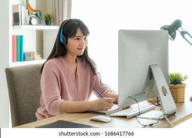 Asian Woman Student Video Conference E-learning With Teacher On Computer In Living Room At Home. E-learning ,online ,education And Internet Social Distancing Protect From COVID-19 Viruses.