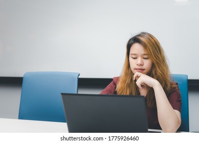 Asian woman is student,businesswoman working by computer notebook, laptop in office meeting room with whiteboard background with thinking, concentrate emotion in concept working woman,success in life - Shutterstock ID 1775926460