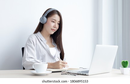Asiatische Frau studiert online durch ihren Laptop in ihrem Haus, bleiben zu Hause, New normal, Covid-19 Coronavirus, Social Diststancing, Internet-Lernen.
