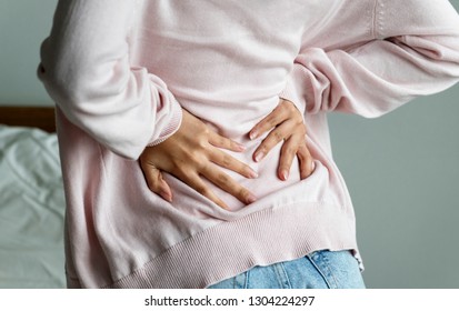 Asian woman suffering back pain - Shutterstock ID 1304224297
