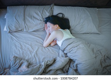 Asian Woman Suffering From Depression On Bed