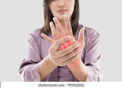 Asian woman suffering from pain in bone against gray background, Concept with hand arthritis grimace in pain - Shutterstock ID 791922025