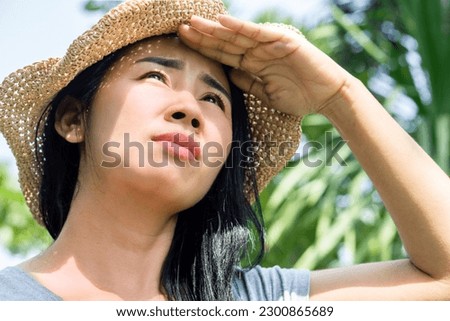 Asian Woman with Sunburned Face Standing Outdoors Under the Summer Sun