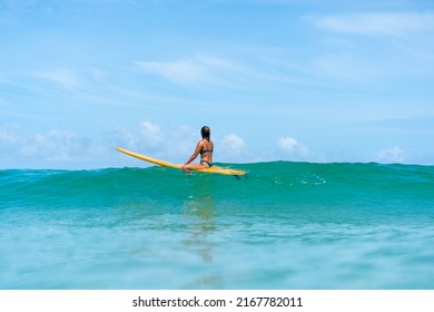 Asian Woman Surfer Paddling Surfboard And Riding The Wave In The Sea At Tropical Beach In Sunny Day. Healthy Female Enjoy Outdoor Activity Lifestyle And Water Sport Exercise Surfing On Summer Vacation