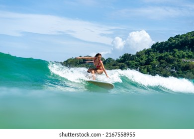 Asian Woman Surfer Surfing And Riding Surfboard  The Wave In The Sea At Tropical Beach In Sunny Day. Healthy Female Enjoy Outdoor Activity Lifestyle And Water Sport Exercise Surfing On Summer Vacation