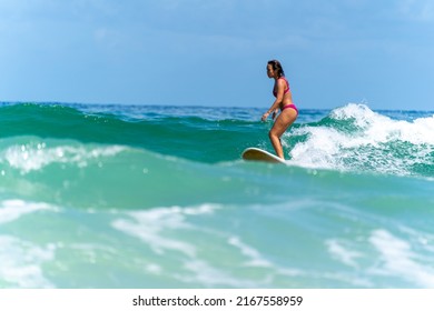 Asian Woman Surfer Surfing And Riding Surfboard  The Wave In The Sea At Tropical Beach In Sunny Day. Healthy Female Enjoy Outdoor Activity Lifestyle And Water Sport Exercise Surfing On Summer Vacation