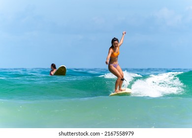 Asian Woman Surfer Surfing And Riding Surfboard  The Wave In The Sea At Tropical Beach In Sunny Day. Healthy Female Enjoy Outdoor Activity Lifestyle And Water Sport Exercise Surfing On Summer Vacation