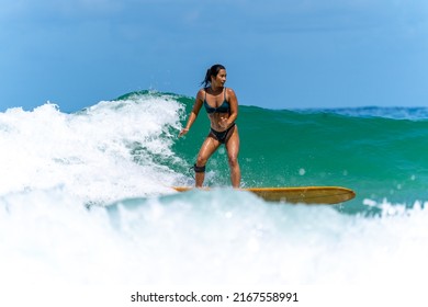 Asian Woman Surfer Surfing And Riding Surfboard  The Wave In The Sea At Tropical Beach In Sunny Day. Healthy Female Enjoy Outdoor Activity Lifestyle And Water Sport Exercise Surfing On Summer Vacation