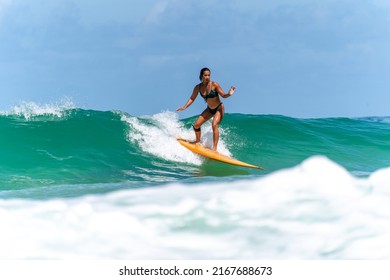 Asian Woman Surfer Surfing And Riding Surfboard  The Wave In The Sea At Tropical Beach In Sunny Day. Healthy Female Enjoy Outdoor Activity Lifestyle And Water Sport Exercise Surfing On Summer Vacation